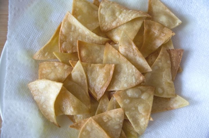 fried tortilla chips draining on paper towels