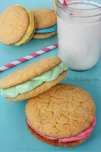 Springtime Filled Cookies in pastel colors with glass of milk and pink striped paper straw