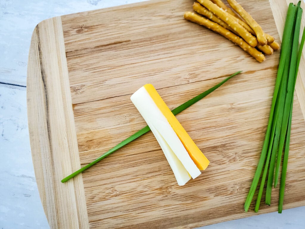 assembling witch broom snack with cheese and chives