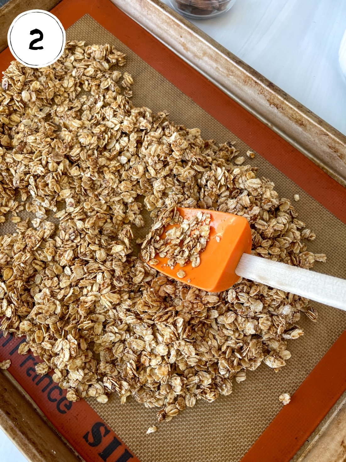 Mixing Pumpkin Granola on baking sheet.