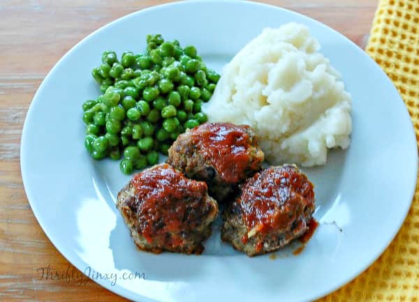 Brown Sugar Ketchup Glazed Meatballs on plate with peas and mashed potatoes.