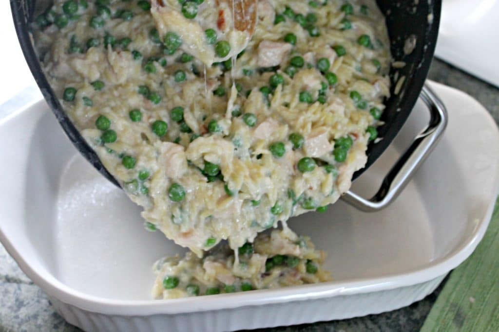 putting Cheesy Chicken and Orzo Casserole into dish