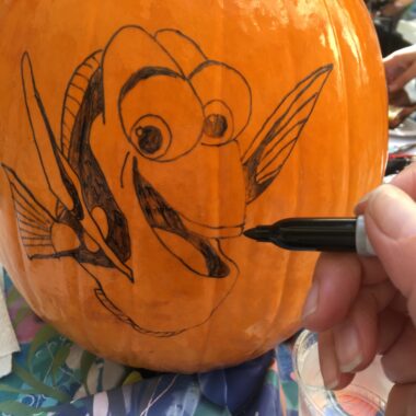Tracing Finding Dory Pumpkin Stencil onto pumpkin with black Sharpie.