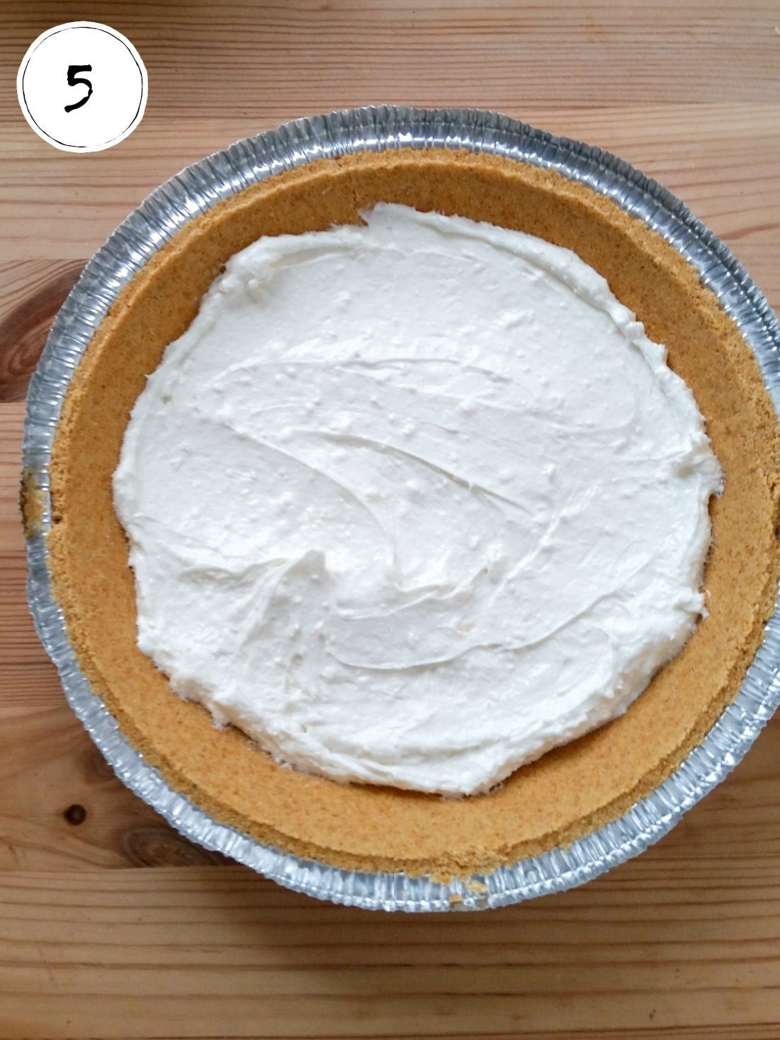 Adding sugar, cream cheese and whipped topping layer to pie crust.