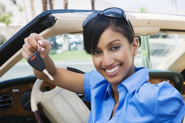 Young Woman Holding Key to Convertible