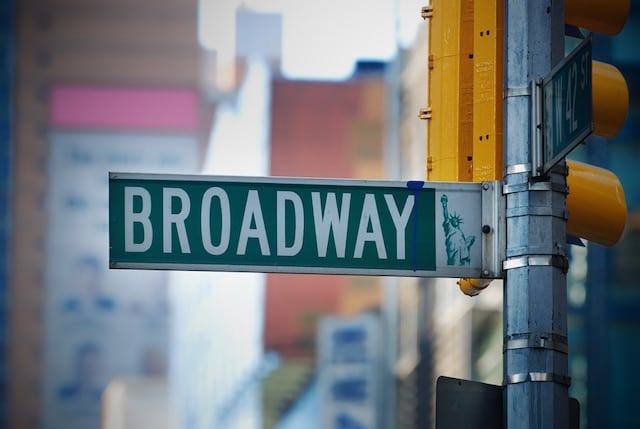 Broadway road sign in Manhattan New York City with skyscrapers.