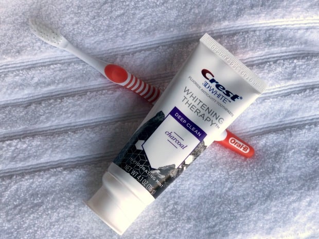 Crest Whitening Therapy Charcoal with toothbrush on towel