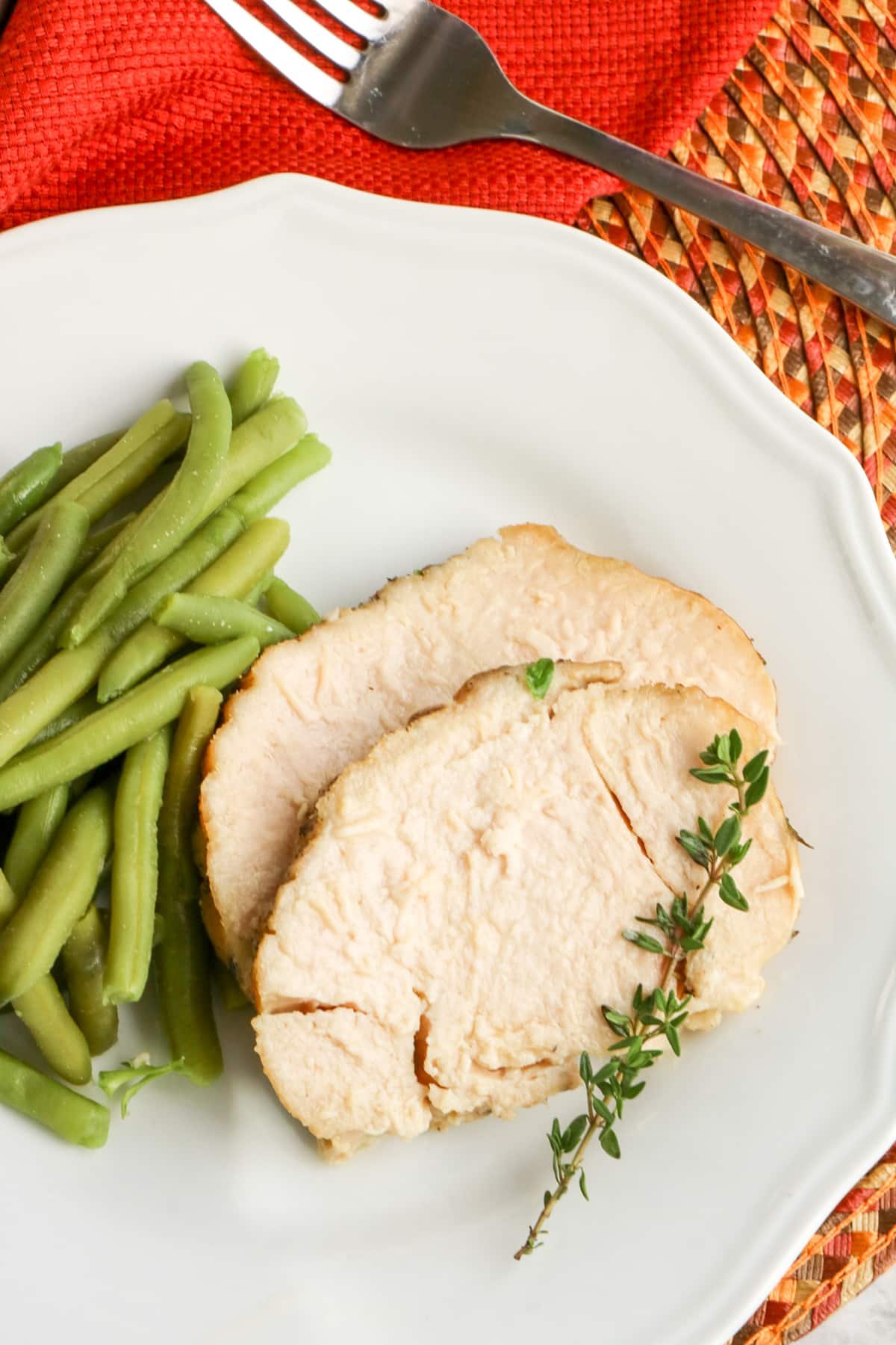 Slow Cooker Turkey Breast on plate with green beans.