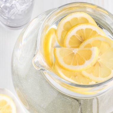 A top down view of a pitcher of lemon water with lemon slices ready for drinking.