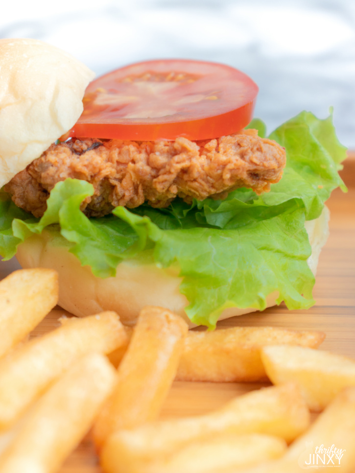Fried Crispy Chicken Sandwich on bun with lettuce and tomatoes and french fries on side