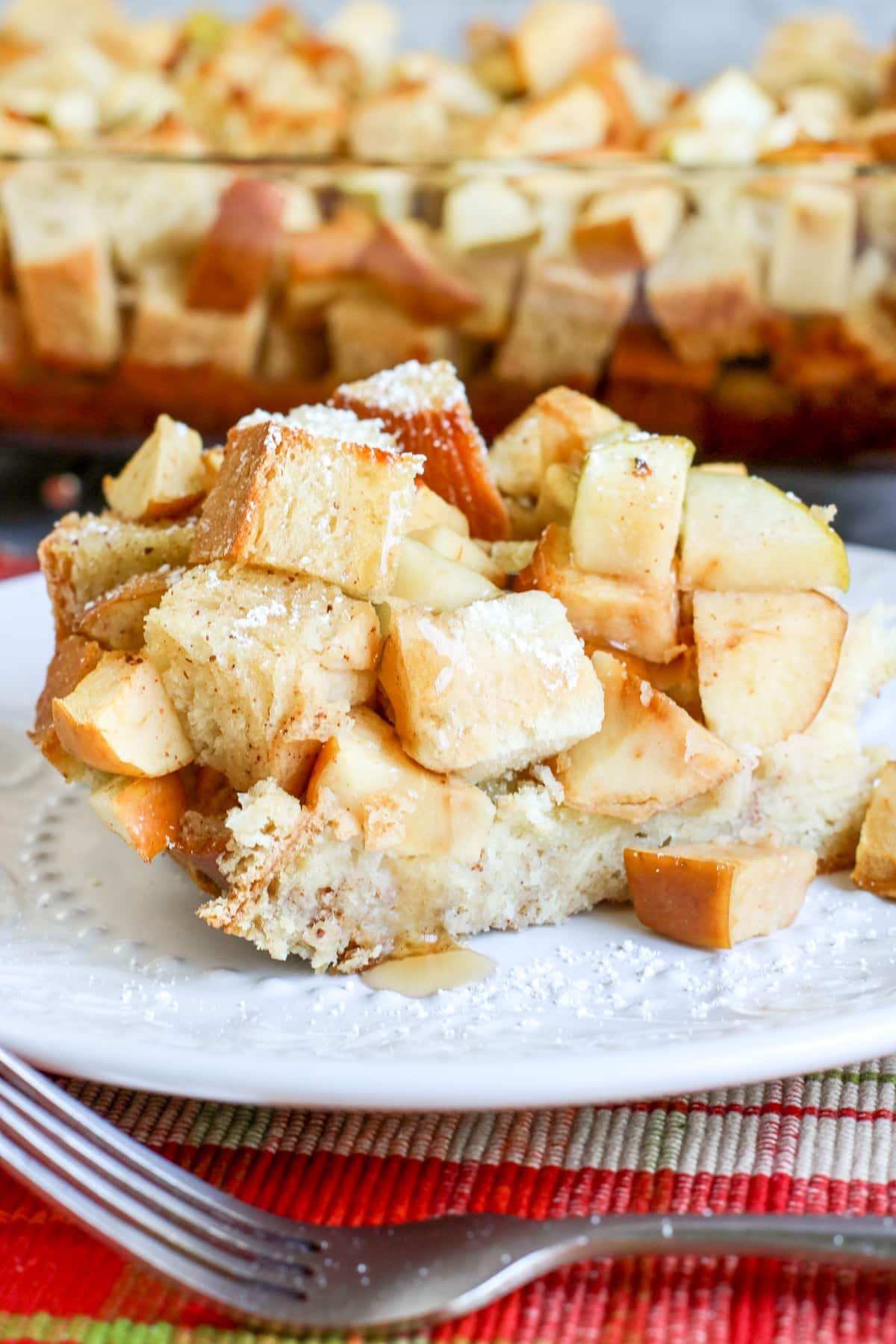 Apple Challah French Toast Casserole served on a white plate with fork in front.