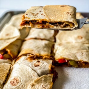 cutting and taking a piece of the baked quesadilla