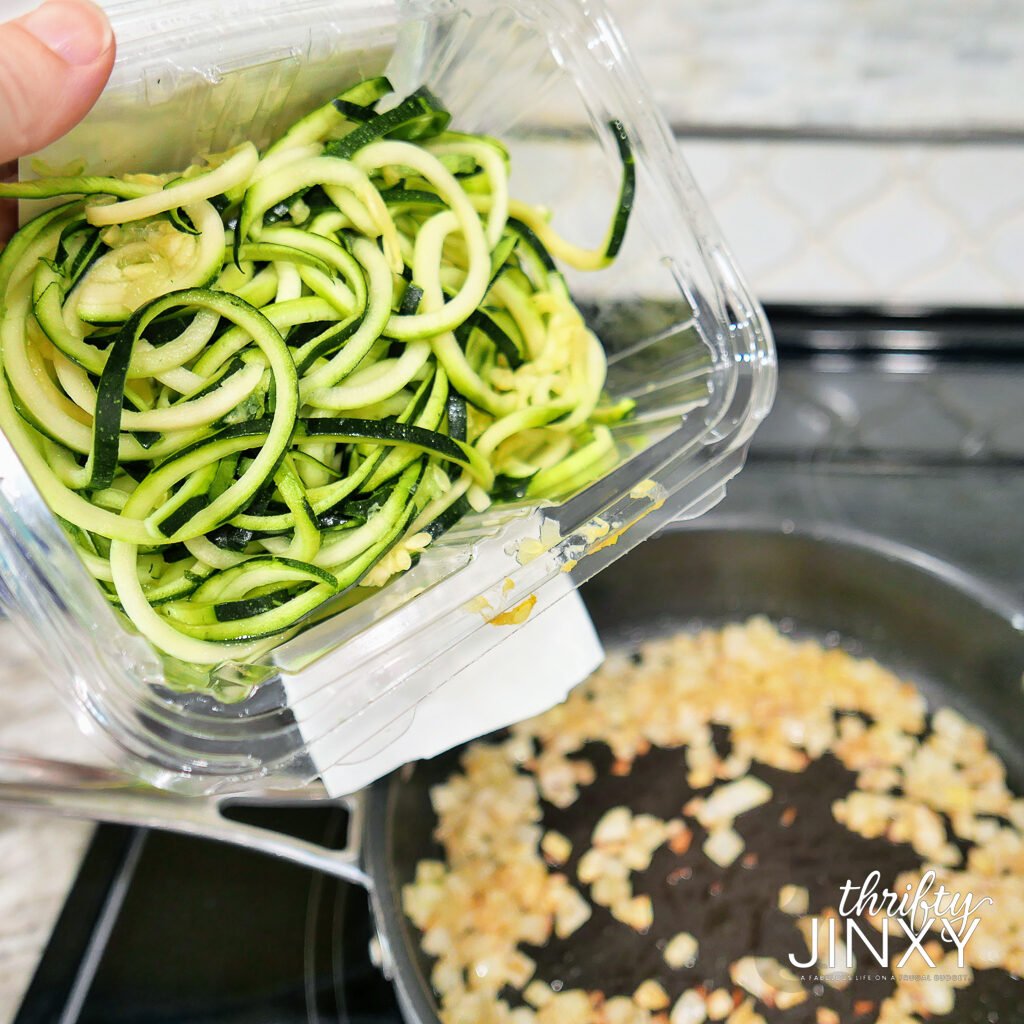 adding packaged zucchini spirals to frying pan