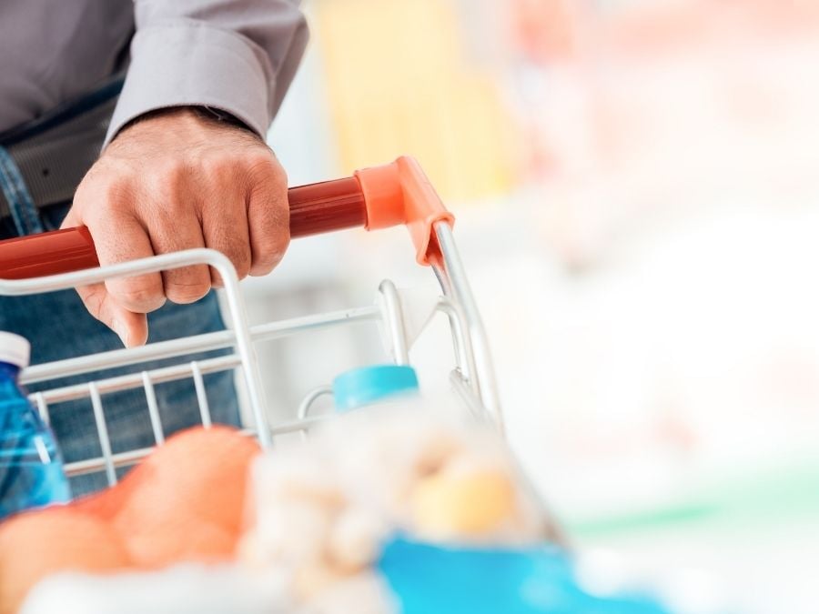 man pushing grocery cart at supermarket