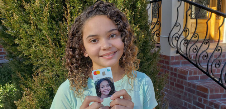 Girl holding Greenlight Debit Card personalized with photo