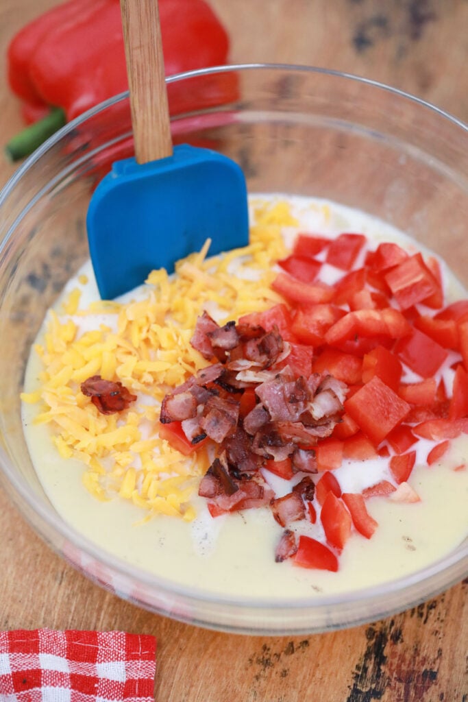 mixing cheese, bacon and tomatoes with cream of mushroom soup