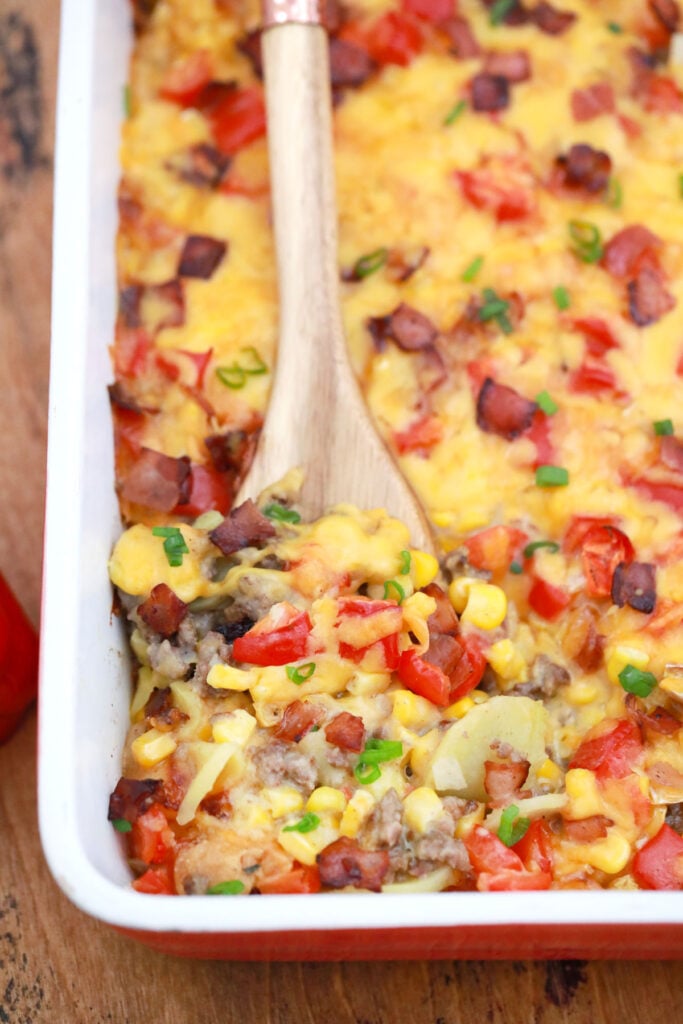 serving hamburger and potato casserole with veggies and cheese