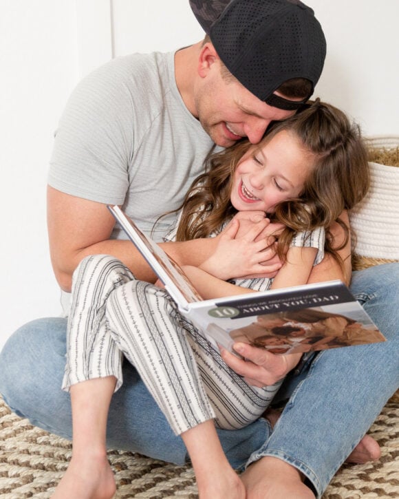 father and daughter looking at Father's Day photo book Mixbook