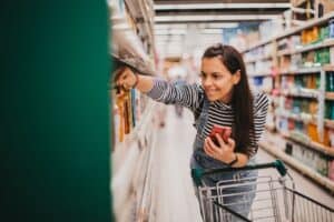 woman finding product on shelf at grocery store