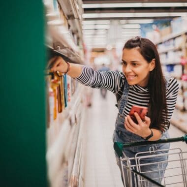 woman finding product on shelf at grocery store