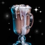 star wars hot chocolate in a glass mug with whipped cream and chocolate syrup dripping down side.