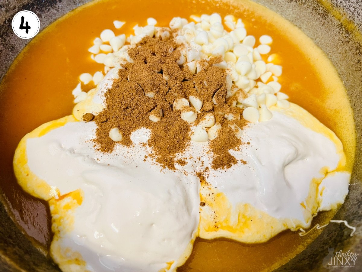 stirring white chocolate chips, marshmallow creme, and pumpkin pie spice into pumpkin fudge mixture.