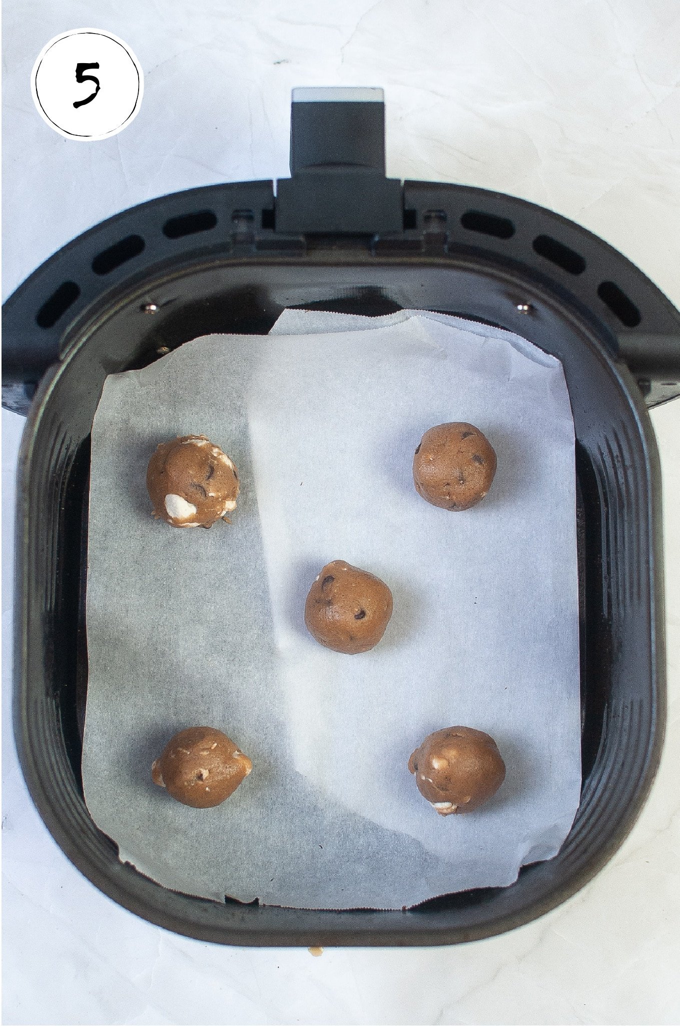 Placing balls of hot chocolate cookie batter in air fryer.