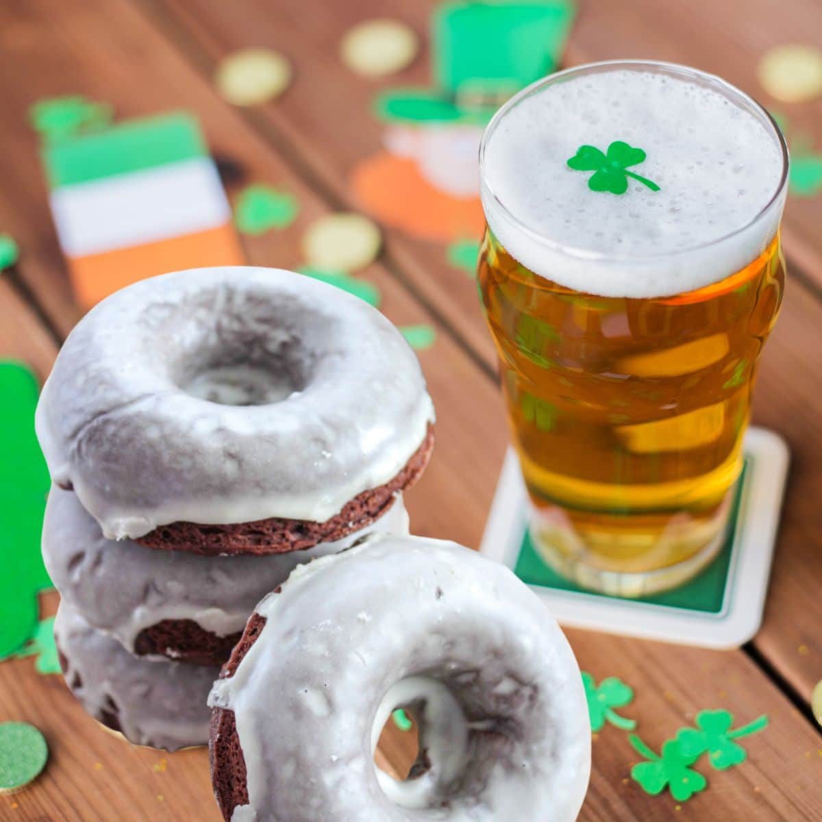 Chocolate Guinness Donuts with Irish Cream Glaze next to a glass of beer.