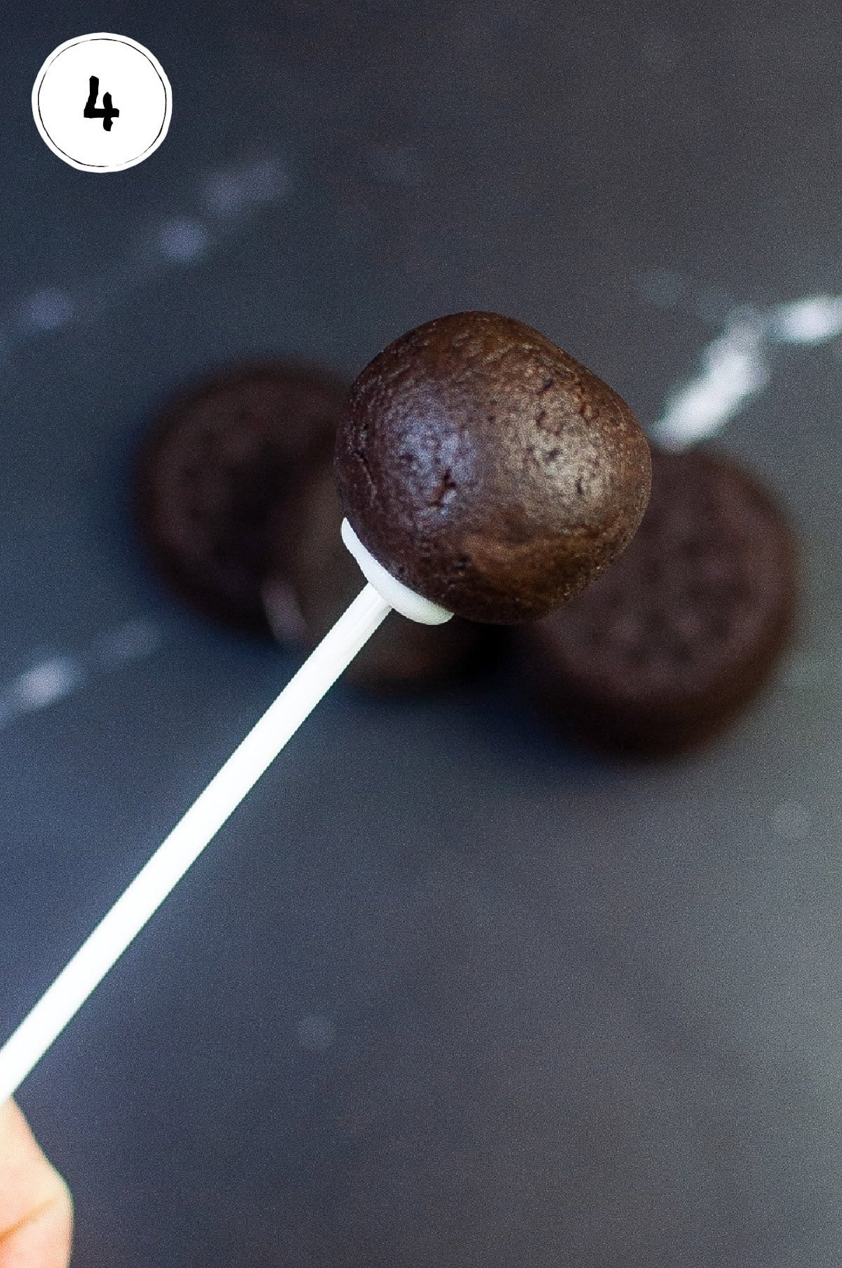 Placing Copycat Starbucks Cookies n Cream Cake Pops on Sticks.