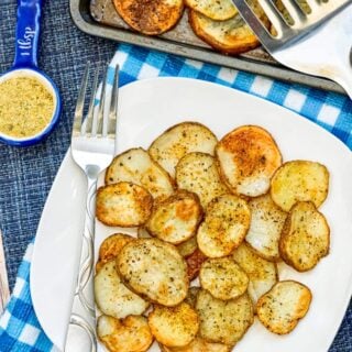 Sheet Pan Garlic Herb Potatoes on a white plate with fork and spatula