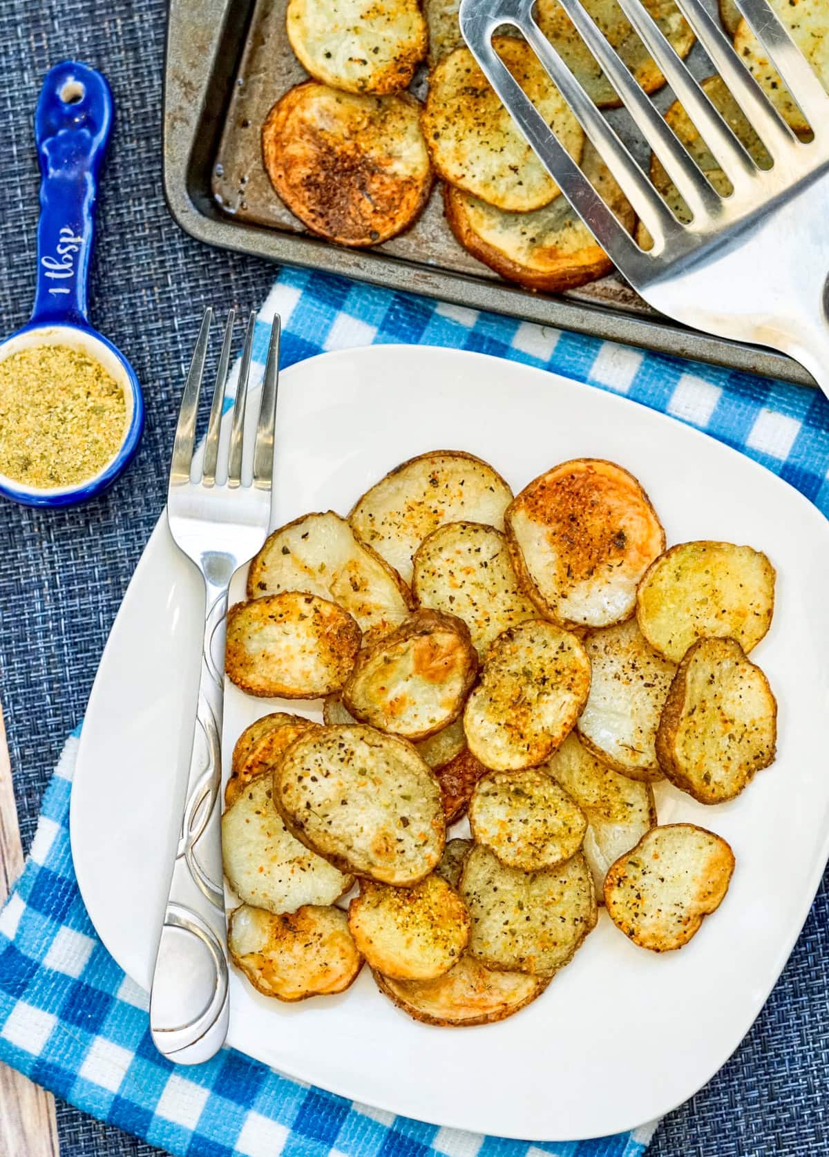 Sheet Pan Garlic Herb Potatoes on a white plate with fork and spatula