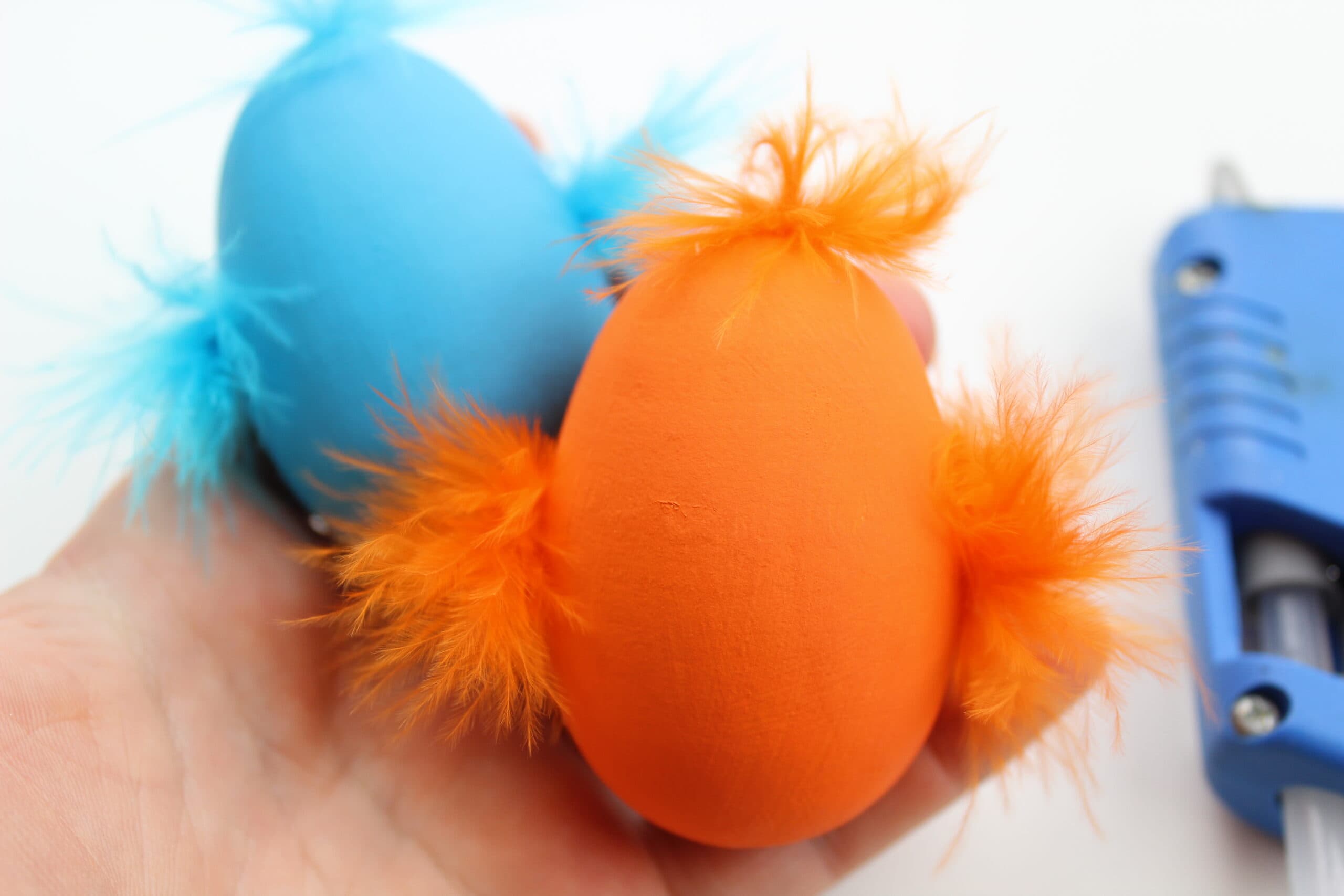 Painted wooden easter eggs with feathers glued on.