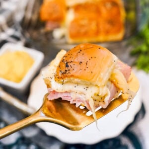 Ham and Swiss Slider being lifted up by a golden spatula.