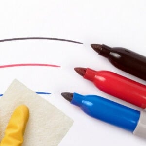 Sharpie marker stains being cleaned by hand with glove and sponge.