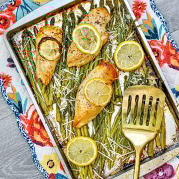 Sheet Pan Chicken and Asparagus on baking pan with spatula.