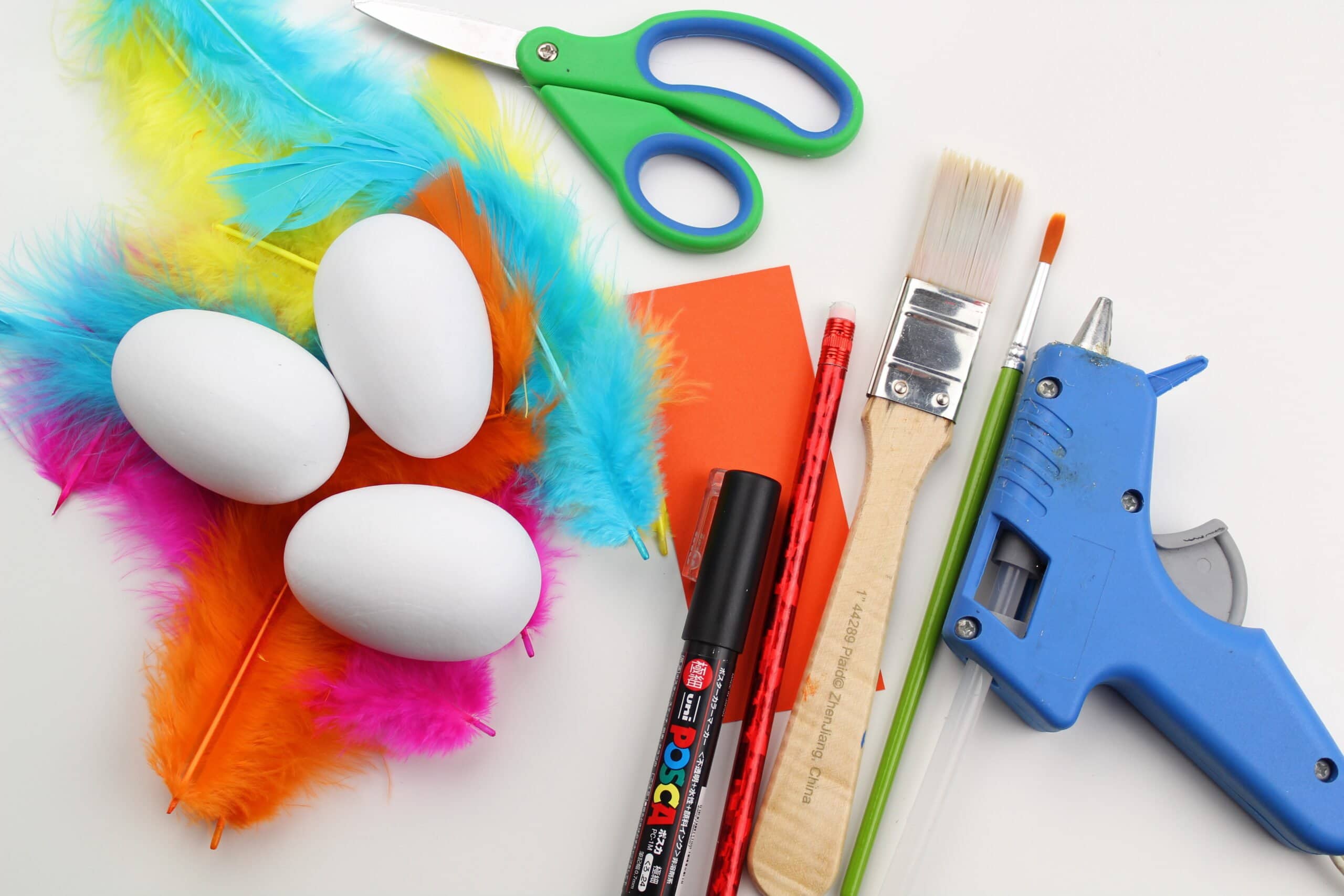 Supplies needed to make Wood Easter Egg Chicks including eggs, feathers, paint, glue gun, paint marker, etc.