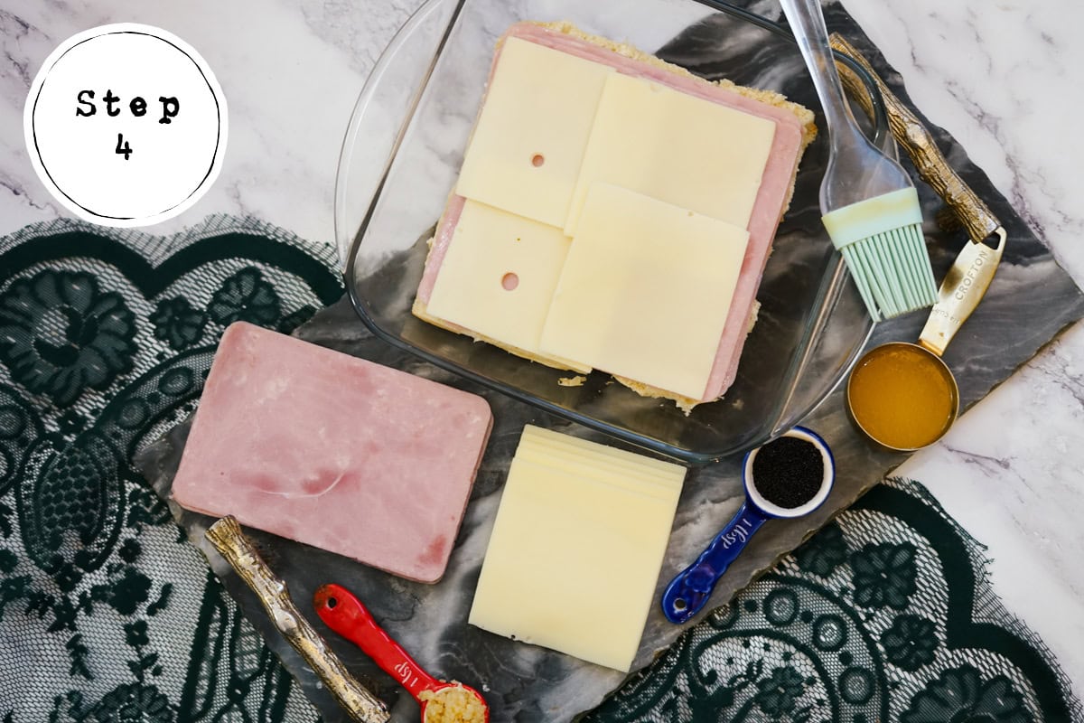 adding cheese to sandwich for Ham and Swiss Sliders.