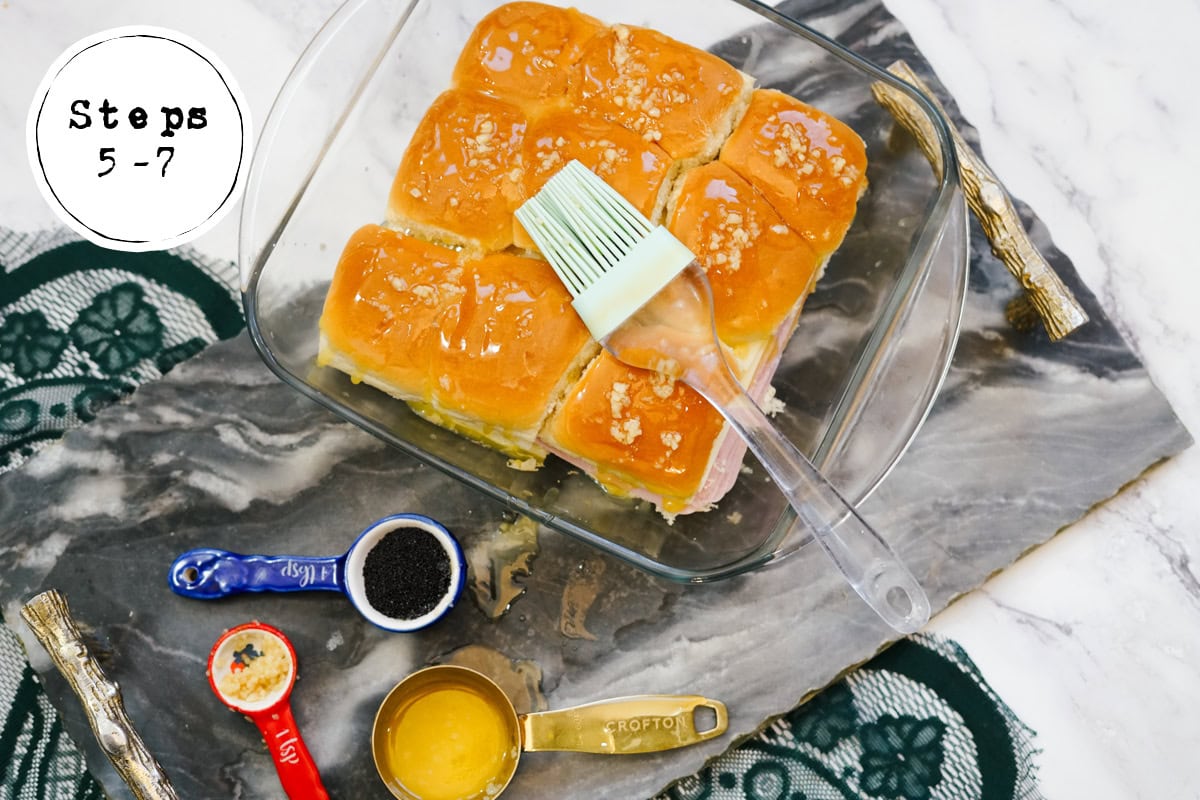 basting seasoned butter on top of Ham and Swiss Sliders.