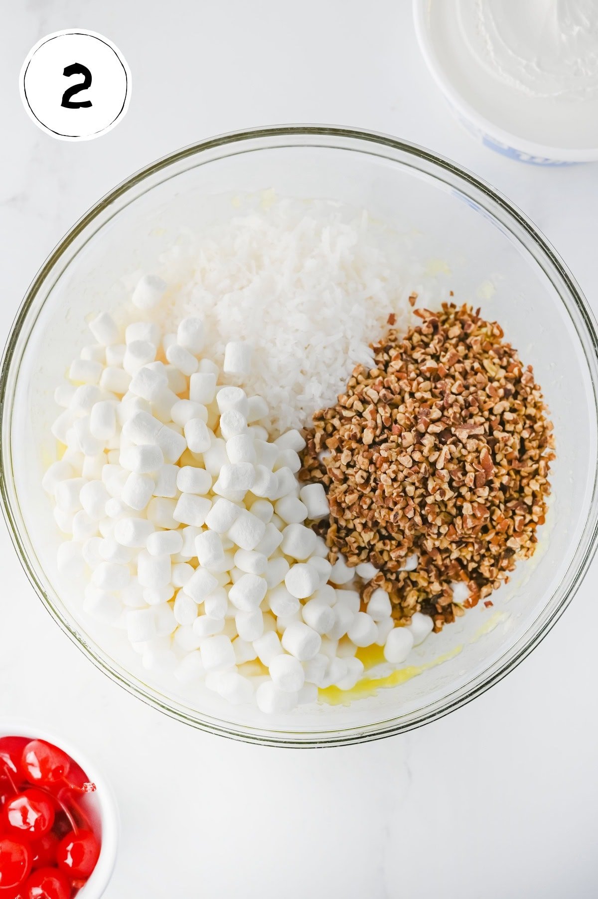 Mixing Ingredients for Pina Colada Fluff Salad in a glass bowl.