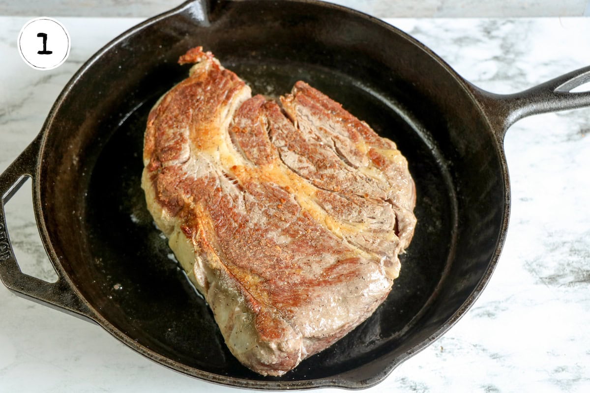 Browning Stovetop Pot Roast in a cast iron pan.