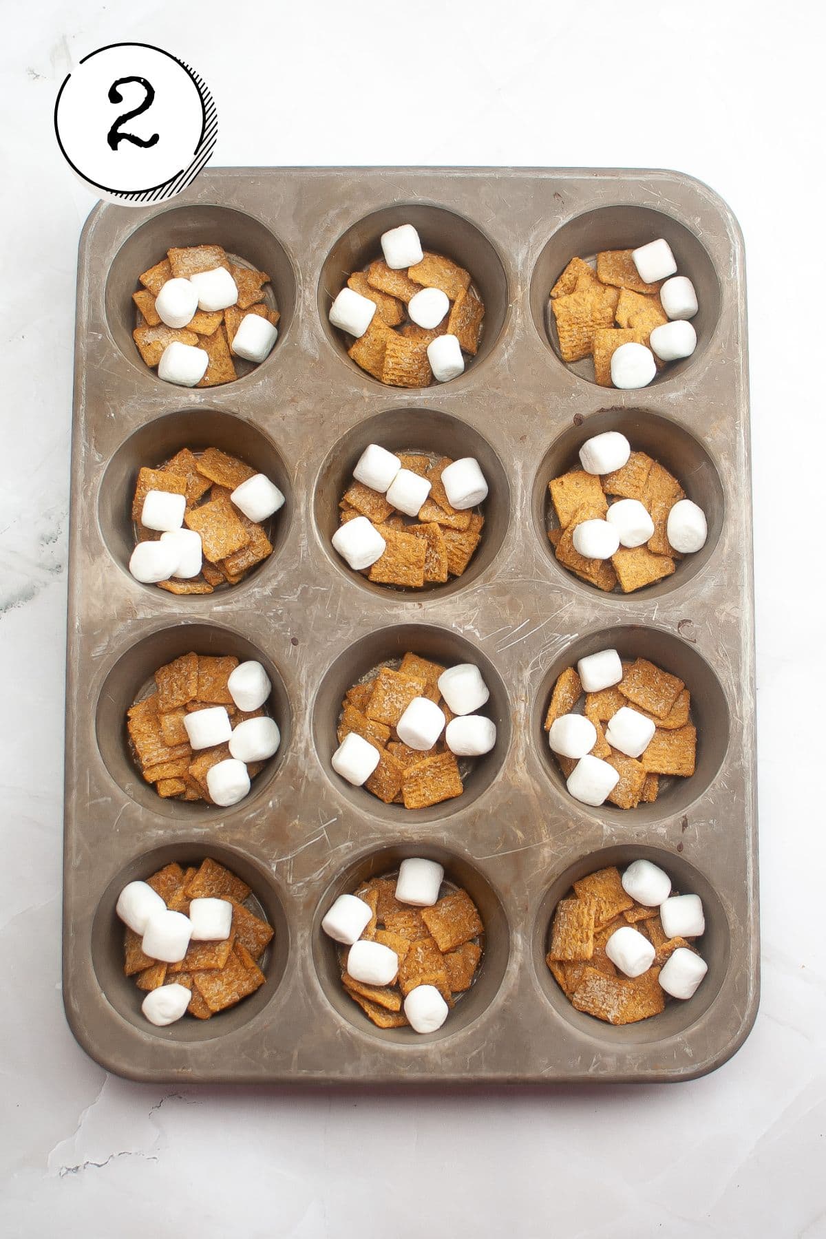 Adding 3-4 marshmallows on top of each portion of cereal.