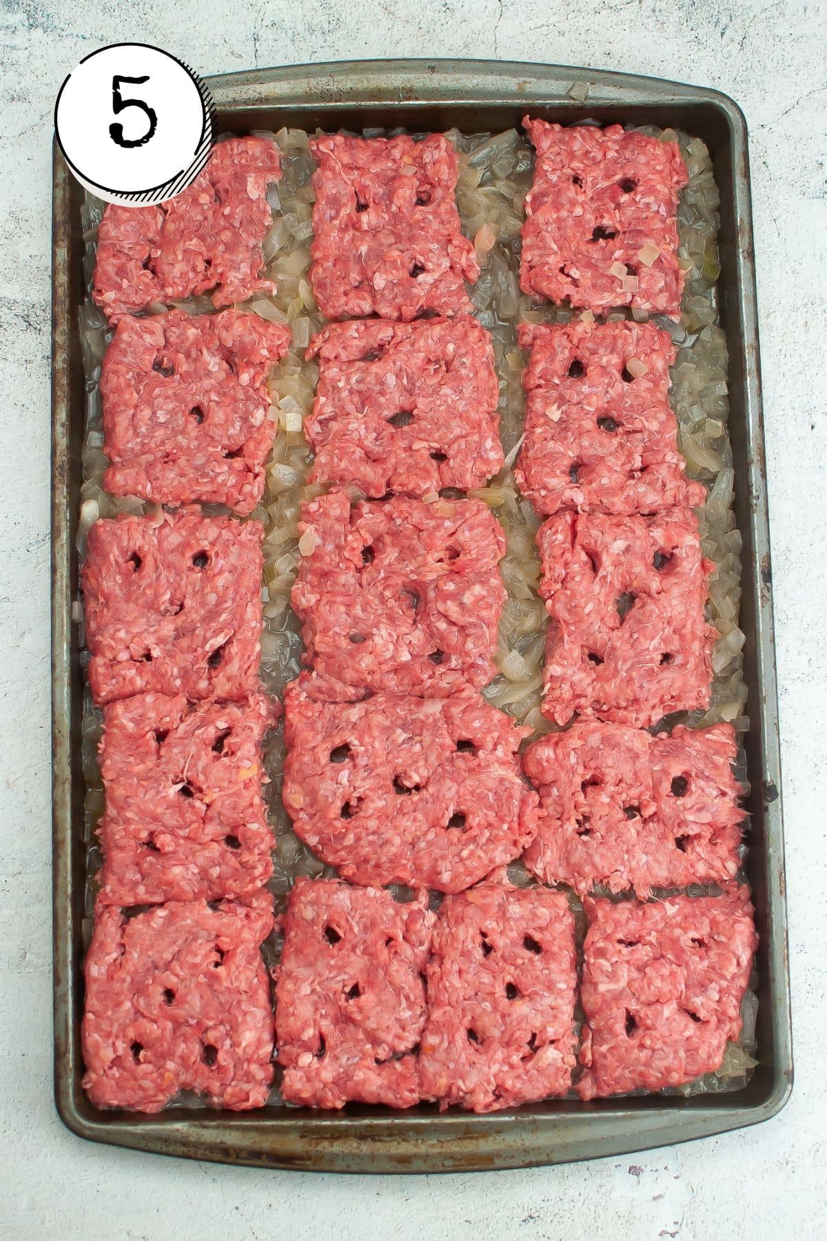 Placing the patties on top of the onion and move baking sheet into the oven, covering with a larger baking sheet that's turned upside down.
