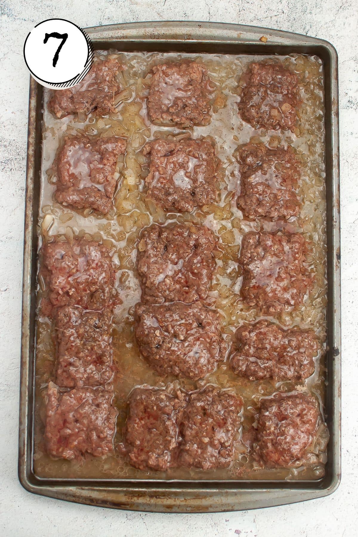 removing burgers from oven and carefully remove top baking sheet