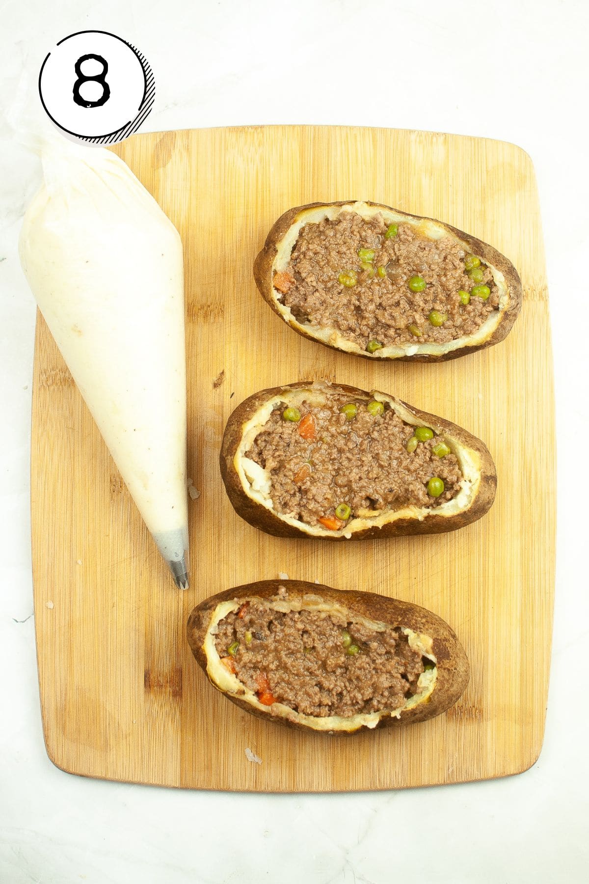 Filling the potatoes with the meat mixture.