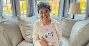 A woman happily showing her Remento book.
