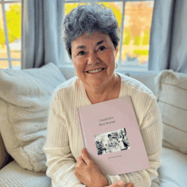 A woman happily showing her Remento book.