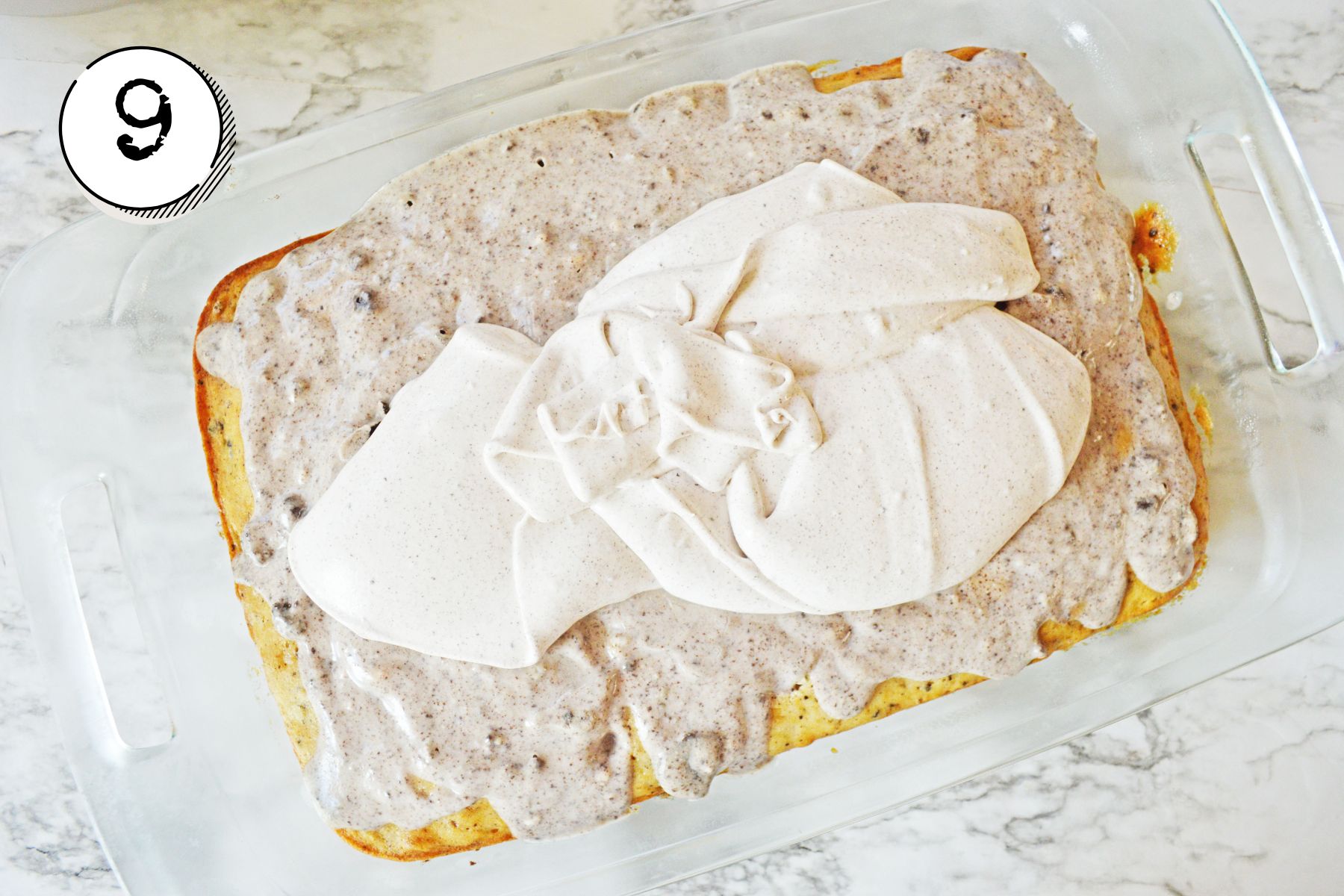 spreading the whipped pudding topping evenly over the chilled cak.