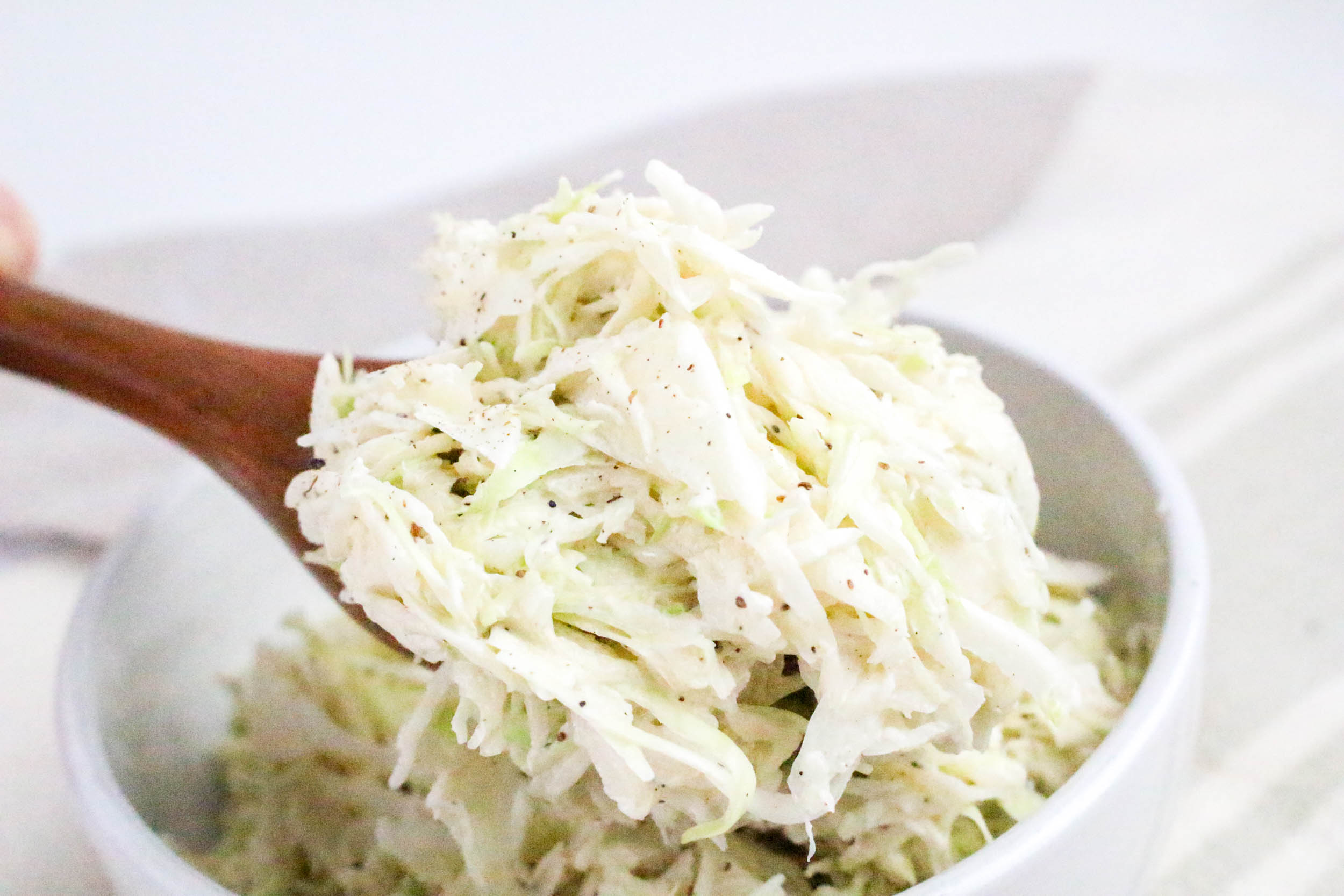 Angel Hair Coleslaw scooped with wooden spoon