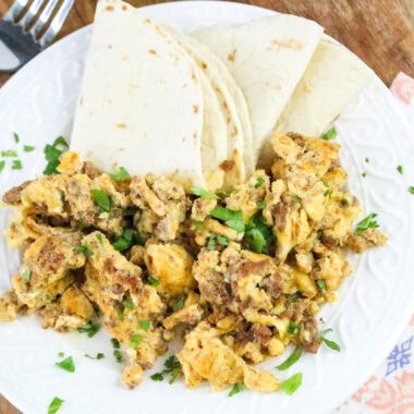Chorizo and Eggs with tortilla on the side in white plate
