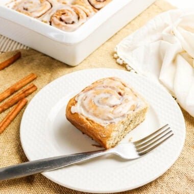 Whole Wheat Cinnamon Rolls a slice with fork and a tray with cinnamon sticks